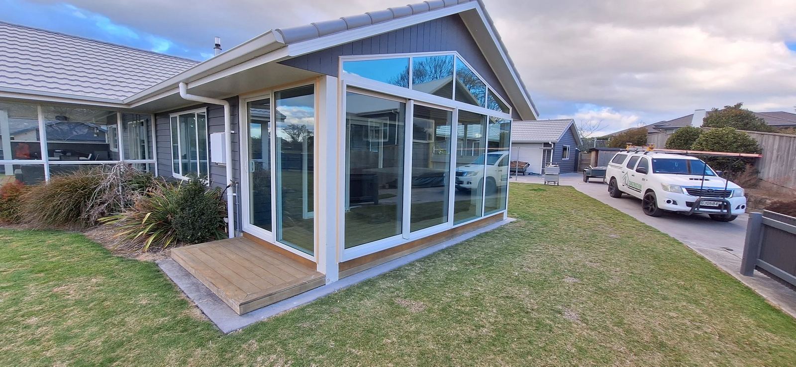 Glazed sunroom and deck on a weatherboard home